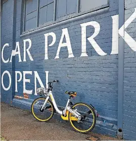  ??  ?? A shareable ‘‘oBike’’ parked jauntily in front of a large car park building in Melbourne.