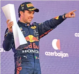  ?? — AFP ?? Red Bull’s Mexican driver Sergio Perez celebrates on the podium after winning the Formula One Azerbaijan Grand Prix in Baku on Sunday.