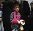  ??  ?? A boy receives food from volunteers in Sanaa, Yemen.