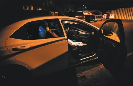  ?? Photos by Gabrielle Lurie / The Chronicle ?? Gregory Smith, 55, checks his phone in his car in the parking lot of the First Presbyteri­an Church of Hayward in Castro Valley.