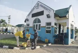  ??  ?? SANITISE. A man washes his hands at the security post to be allowed into Redeemer’s University.