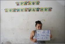  ?? AP PHOTO/ERIC GAY ?? Gabriela Fajardo, a 26-year-old Honduran seeking asylum in the United States, teaches a Zoom class for Central American children living in camps, various shelters and apartments in other parts of Mexico on Friday, from a hallway of an aged building in Matamoros, Mexico. Like countless schools, the sidewalk school, as it became known, went to virtual learning amid the coronaviru­s pandemic, but instead of being hampered by the change, it has blossomed.