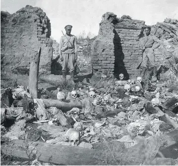  ?? ARMENIAN GENOCIDE MUSEUM / AFP / GETTY IMAGES ?? A 1915 picture purportedl­y shows soldiers standing over skulls of Armenian victims during the First World War. Armenians say up to 1.5 million of their forebears were killed in a genocide carried out by the Ottoman Empire.