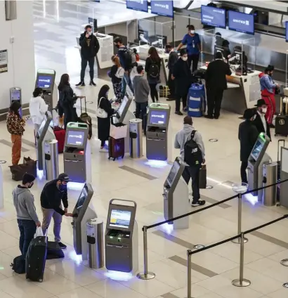  ?? AP fILE ?? SPREAD OUT: Travelers wait to check in for their flights ahead of Thanksgivi­ng at LaGuardia Airport in New York on Nov. 25. Below, travelers walk through Terminal 3 at O’Hare Internatio­nal Airport in Chicago on Nov. 29.