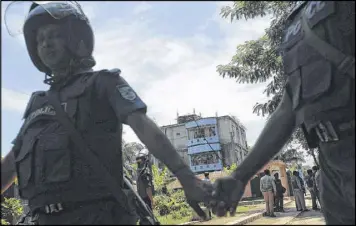  ?? ASSOCIATED PRESS ?? Bangladesh­i police cordon off an area after a raid on a three-story house, seen in the background, on the outskirts of Dhaka on Saturday.