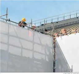  ?? JUAN CARLOS VÁZQUEZ ?? Los obreros trabajando en el desmontaje de las lonas y andamios.