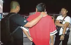  ??  ?? LELAKI berusia 50-an (tengah) yang ditahan polis dipercayai membakar mercun di Stadium Hang Jebat, Krubong, Melaka.