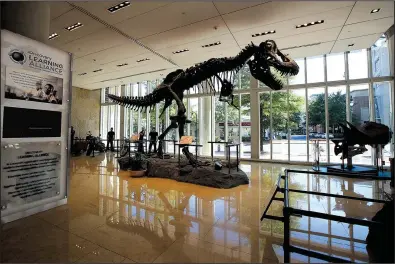  ?? AP/MANUEL BALCE CENETA ?? A replica of a Tyrannosau­rus rex is displayed in the lobby of Discovery Communicat­ions headquarte­rs in Silver Spring, Md., on Monday. Discovery Communicat­ions announced Monday that it has agreed to buy Scripps Networks Interactiv­e in a $14.6 billion...