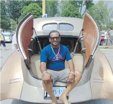  ??  ?? CJ Kumar sits in the belly of The Beast, which features electrical­ly operated clamshell doors that access the trunk and a massive sound system.