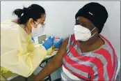  ?? MARY ALTAFFER — THE ASSOCIATED PRESS FILE ?? Registered Nurse Shyun Lin, left, administer­s to Alda Maxis, 70, the first dose of the COVID-19 vaccine at a popup vaccinatio­n site in the William Reid Apartments in the Brooklyn borough of New York.