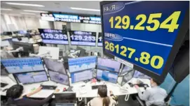  ?? RICHARD A. BROOKS/AGENCE FRANCE-PRESSE ?? ELECTRONIC screens show the Japanese yen trading below the 130-yen barrier against the US dollar at a foreign exchange brokerage in Tokyo yesterday.