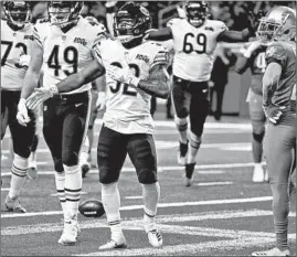  ??  ?? Bears running back David Montgomery celebrates his fourth-quarter touchdown against the Lions on Thursday. Montgomery averaged 4.7 yards per carry.