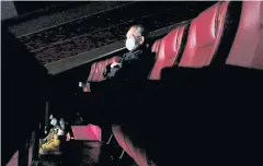  ??  ?? A man wears protective mask as he watches a movie in Hong Kong on Feb 10.