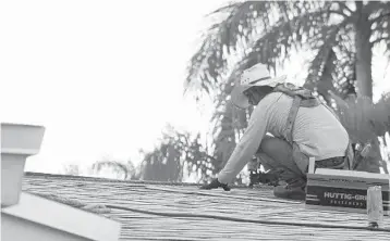  ?? ROB KORNAHRENS/COURTESYPH­OTOS ?? A volunteer works to replace Gloria Mugford’s roof.