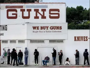  ?? (AP/Ringo H.W. Chiu) ?? People wait in line Sunday to enter a gun store in Culver City, Calif. The coronaviru­s pandemic has fueled a spike in firearms sales.