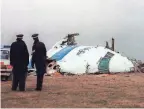  ?? ROY LETKEY/AFP VIA GETTY IMAGES ?? The day after the Dec. 21, 1988, bombing of Pan Am
Flight 103 over Lockerbie, Scotland, police officers look at the wreckage of the Boeing 747.