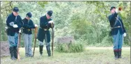  ?? Westside Eagle Observer/SUSAN HOLLAND ?? Members of McPherson Camp #1, Sons of Union Veterans of the Civil War in Rogers, bow their heads and rest on their rifles while camp bugler Jim Spillars plays taps. Pictured are riflemen Bob Underdown and Jacob Spillars, who along with Jim Spillars had just finished firing a memorial volley, and camp commander Joe Rainey.