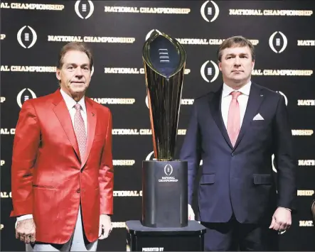  ?? David Goldman / Associated Press ?? Alabama head coach Nick Saban, left, and Georgia head coach Kirby Smart pose with the NCAA college football championsh­ip trophy at a press conference in Atlanta on Sunday. Smart spent plenty of time under mentor Saban on the sideline at Alabama....