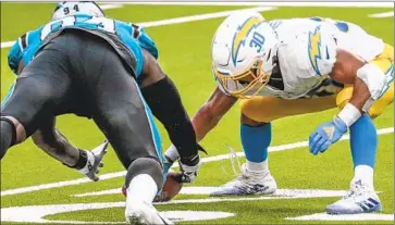  ?? Robert Gauthier Los Angeles Times ?? AUSTIN EKELER can’t grab the ball after a failed, f inal lateral as Carolina’s Efe Obada recovers the fumble.