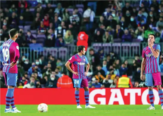  ?? AP ?? Ferran, Eric García y Busquets se lamentan tras el gol del Cádiz