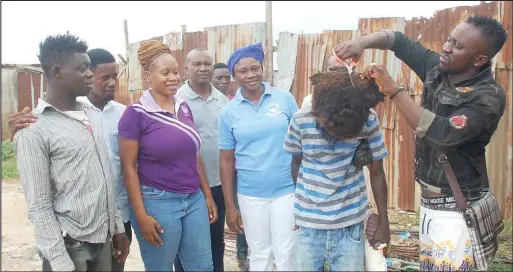  ??  ?? Ezeh (centre) with volunteers on a community service