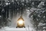  ?? AP FILE PHOTO ?? A snowmobile travels a newly-groomed trail in East Montpelier, Vermont, in this Dec. 31, 2012, photo. With plenty of fresh snow covering much of northern New England, the 2017 winter snowmobile season is off to a good start.