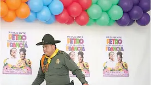  ?? AP Photo/Fernando Vergara ?? ■ A police officer walks past posters of Historical Pact coalition presidenti­al candidate Gustavo Petro and his running mate Francia Marquez during a closing campaign rally May 22 in Zipaquira, Colombia. Elections are set for today.