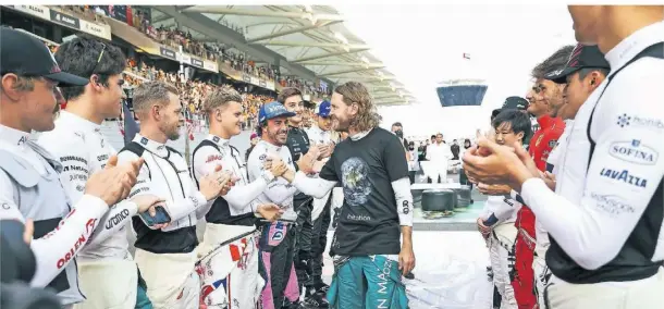  ?? FOTO: IMAGO/FLORENT GOODEN ?? Ehre, wem Ehre gebührt: Die Formel-1-Piloten verabschie­den Sebastian Vettel in Abu Dhabi.