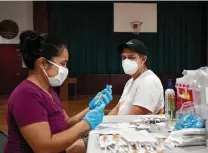  ?? James Estrin / New York Times ?? A health care worker prepares a vaccine dose in New York City. The Biden administra­tion said Wednesday that it would provide booster shots to most Americans beginning as soon as Sept. 20.