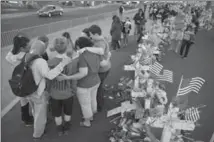  ?? JOHN LOCHER, THE ASSOCIATED PRESS ?? People pray at a makeshift memorial for victims of a mass shooting earlier this month in Las Vegas.