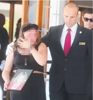  ?? Picture: RICHARD GOSLING ?? Daughter Ella, 13, is consoled as she leaves the funeral of her mother Kym Cobby at St Peter’s Anglican Church, Southport.