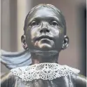  ??  ?? Wall Street’s Fearless Girl statue wears a lace collar in Ginsburg’s memory.