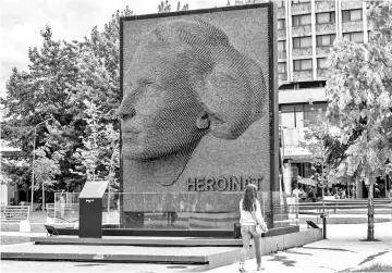  ?? — AFP photos by Armend Nimani ?? A woman walks past a monument entitled “Heroines” honouring the contributi­on and sacrifice of every ethnic Albanian woman during the 1998-1999 war in Kosovo, in Pristina, on July 26, 2018.