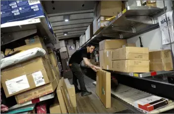  ??  ?? In this May 9 photo, a UPS employee loads packages onto a truck at a company facility in New York. With Christmas on a Monday, most retailers have one less day to get packages delivered on time. UPS said earlier in December that some package deliveries...