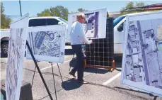  ?? GREG SORBER/JOURNAL ?? Johnny Chandler of the city’s Department of Municipal Developmen­t sets up aerial site photos of the first phase of a solar energy project that includes solar panel installati­on at 12 city-owned buildings before a Monday news conference.