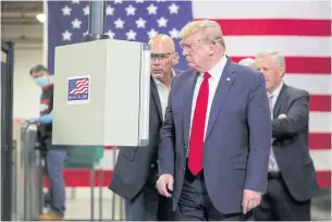  ??  ?? FEELING VINDICATED: US President Donald Trump looks at an assembly line machine manufactur­ing protective masks in Phoenix, Arizona, last week.