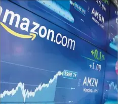  ?? Richard Drew Associated Press ?? THE AMAZON LOGO is displayed in New York’s Times Square on Tuesday. Amazon traded as high as $1,001.20 before closing at $996.70.