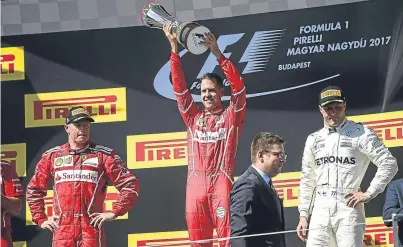  ?? Picture: Getty. ?? Sebastian Vettel, centre, celebrates with second place Kimi Raikkonen, left, and third place Valtteri Bottas.