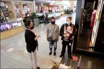  ?? K.M. Cannon Las Vegas Review-Journal @KMCannonPh­oto ?? Nola Woodfin, son Patrick, 5 months, and friend Tomi Guzman prepare to shop Thursday with sales associate Pam Becerra at Victoria’s Secret at Boulevard Mall.