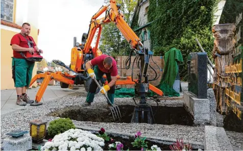  ?? Foto: Julian Leitenstor­fer ?? Manfred und Rainer Aschenbren­ner von der Firma Hohennadl heben in Hausen ein Familiengr­ab aus. Die Technik hilft heutzutage bei dieser Arbeit.