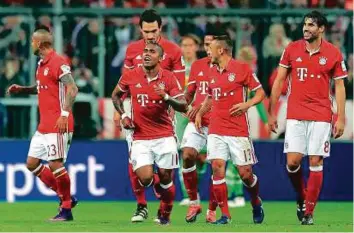  ?? AP ?? Bayern’s Douglas Costa (second from left) celebrates with teammates after scoring his side’s second goal against Borussia Moenchengl­adbach in the win at the Allianz Arena.