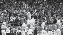  ?? Kin Man Hui/staff photograph­er ?? Devin Duvernay gets lifted by teammate Zach Shackelfor­d after scoring in Texas’ win over Utah at the 2019 Valero Alamo Bowl.