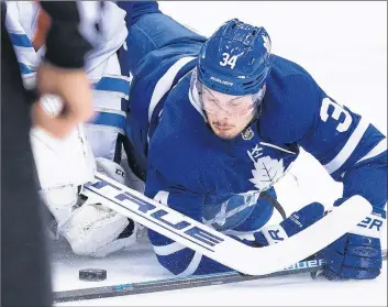  ?? CP PHOTO ?? Toronto Maple Leafs’ Auston Matthews battles for the loose puck with Winnipeg Jets goaltender Connor Hellebuyck during NHL action Saturday night in Toronto.