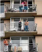  ?? AP ?? People on apartment balconies applaud and make noise in a daily show of support for healthcare workers who are fighting the coronaviru­s, in the West End of Vancouver, British Columbia, yesterday.