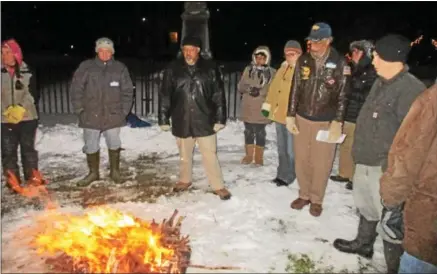  ?? PHOTO SPECIAL TO THE DISPATCH BY MIKE JAQUAYS ?? A crowd reflects on the words of retired Navy Commander Owen Corpin, seen in his aviator’s jacket on the right, after he read the Emancipati­on Proclamati­on Dec. 31, 2016, by the watch fire on the Peterboro Green. This year’s Watch Night will be Sunday,...