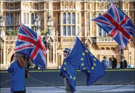  ?? JACK TAYLOR / GETTY IMAGES ?? Anti-Brexit protesters wave Union Jack and EU flags outside the Houses of Parliament in London on Friday. British Prime Minister Theresa May struck a deal with the European Union before Brexit talks move on to the next phase.