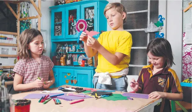  ?? Picture: BRENDAN RADKE ?? Steer family siblings Rosie, 8, Joe, 10, and Audrey, 6, work on some collages ahead of the school holidays art workshops in Cairns.