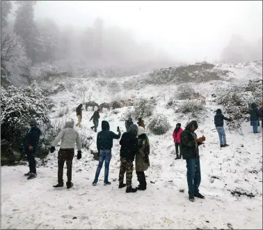  ?? IANS ?? Tourists enjoy themselves during fresh snowfall at Kufri in Shimla on Thursday.