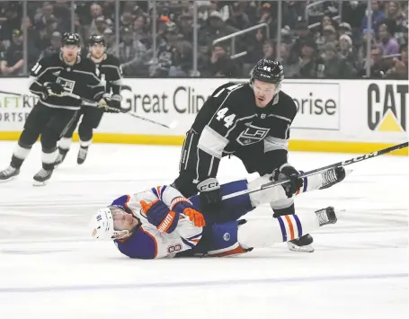  ?? MARK J. TERRILL/THE ASSOCIATED PRESS ?? Zach Hyman of the Edmonton Oilers falls to the ice after colliding with the Los Angeles Kings' Mikey Anderson in Game 4 of their playoff series Sunday in Los Angeles. On average there have been 1.5 more hits per game so far in the NHL playoffs.