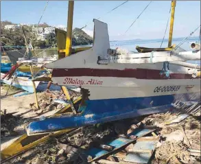  ??  ?? This handout photo received yesterday shows a boat damaged by the typhoon, on Bulabog beach on the island of Boracay.